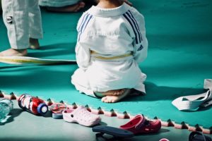 Enfant assis en tailleur de dos sur tatamis